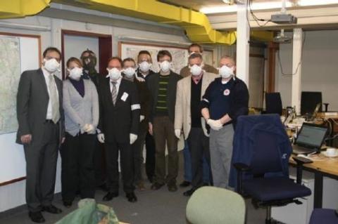 Männer mit Schutzmasken stehen in einem Raum