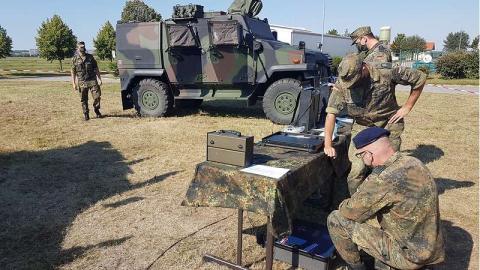 Bundeswehr übt mit Funkgeräten im Gelände.